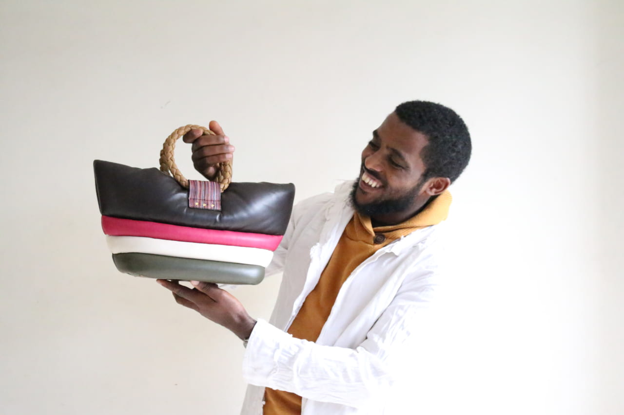 自分たちでつくったバッグを手にして笑顔の職人さん。