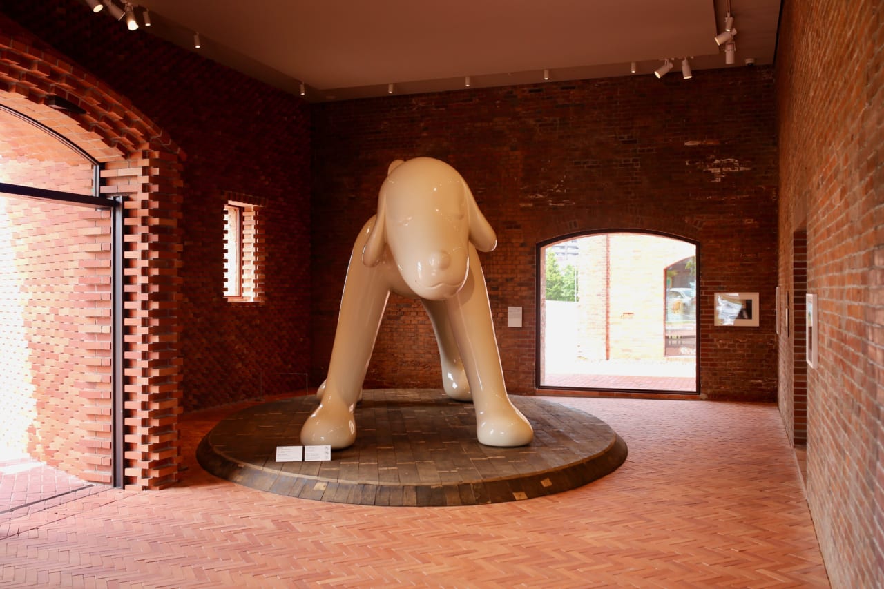 弘前れんが倉庫美術館の入口を入ると、奈良美智さんの《A to Z Memorial Dog》がお出迎え。©︎Yoshitomo Nara