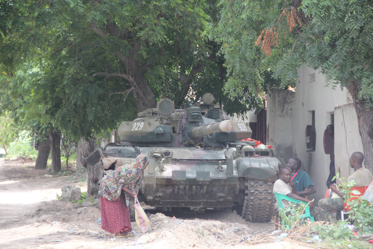 戦車の前でお茶を飲んでくつろぐ人々。内戦中のソマリアにて。