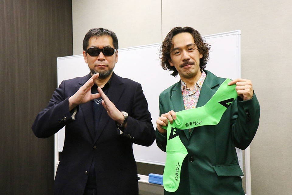 編集長からプレゼントされた特製「ムー」ソックスを手に。