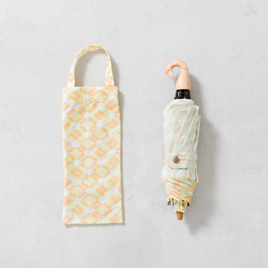 ▲「ORANGE/YELLOW」の傘は、
持ち手やボタン、先端の部分も
全て木のパーツを使用しました。