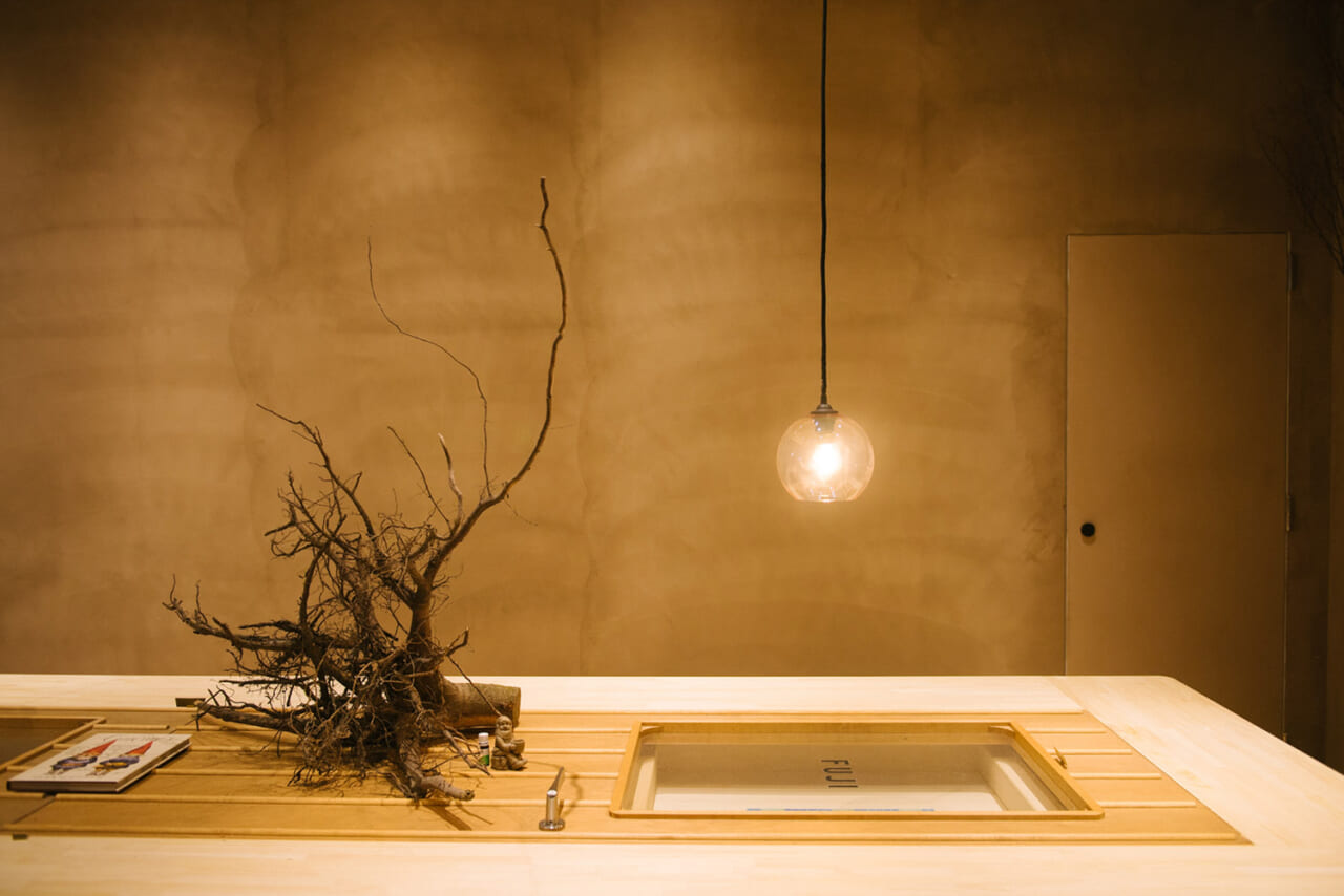▲サウナラボ神田の共有スペース。テーブルの上には、泥がついたままの木の根っこ。