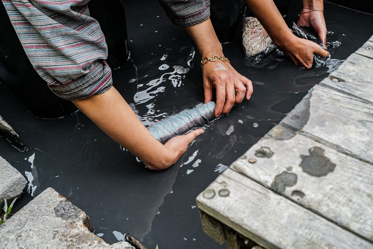 ▲毛糸を泥に浸して、揉み込んでいきます。泥は生温かく、気持ちが良いもの。