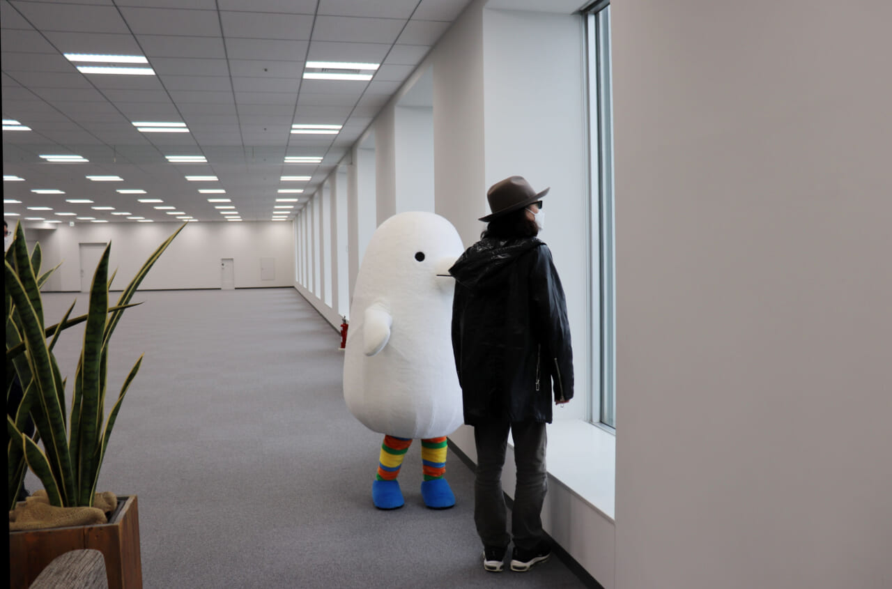 ▲生活のたのしみ展のキャラクター「ほぼトリドリ」と広い部屋にいる、みうらさん。