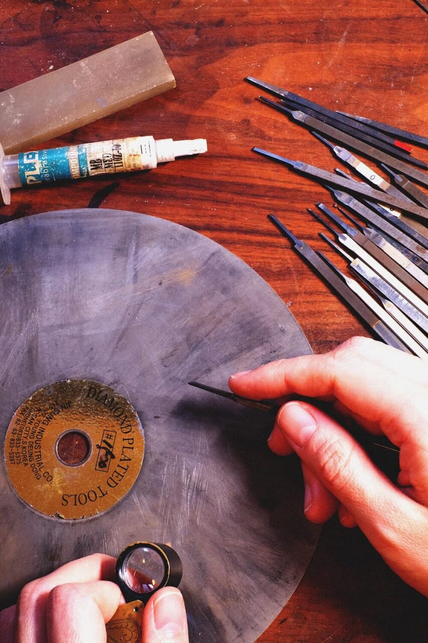 提供写真：右にずらりと並ぶのがタガネ。ダイヤモンドディスクと呼ばれる板で研磨する。