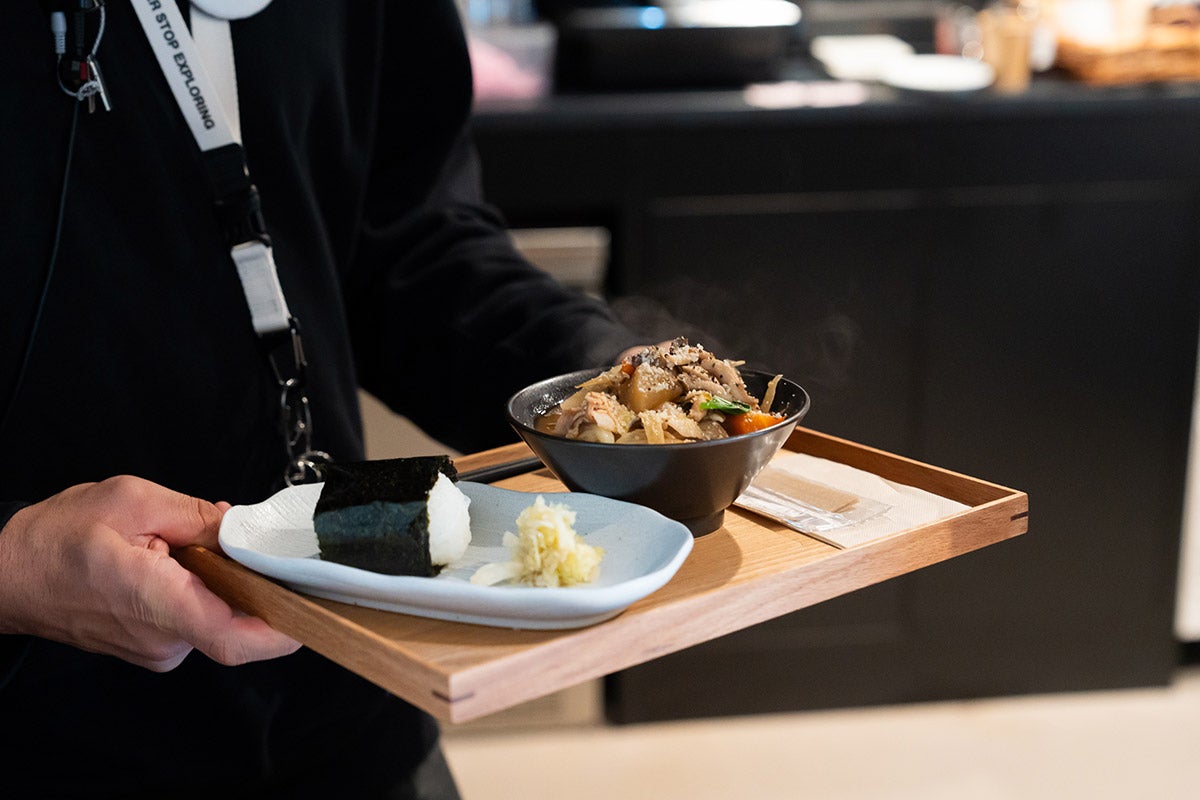 名物の豚汁とおにぎりのセットを配膳している