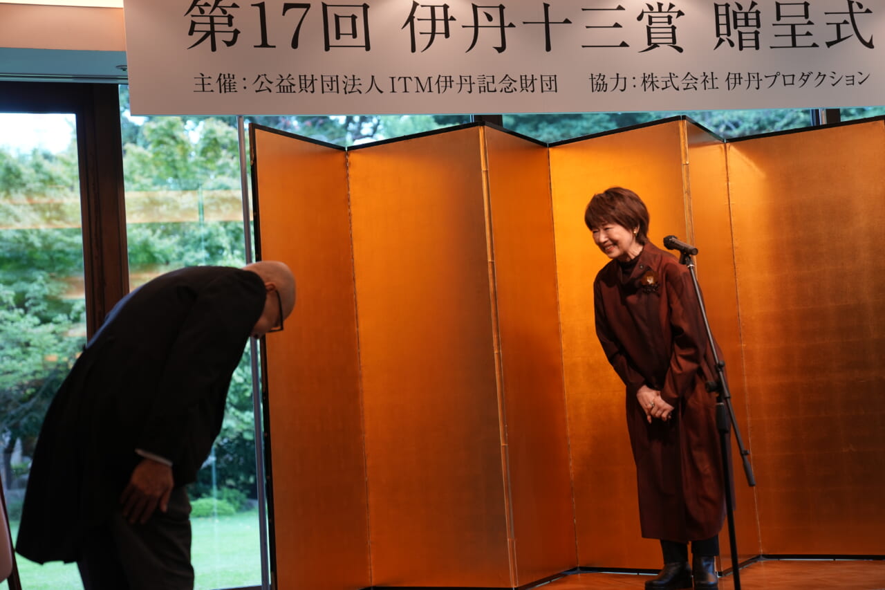宮本信子さんが壇上に上がり、左側に立った山田五郎さんとお辞儀をしあっています。