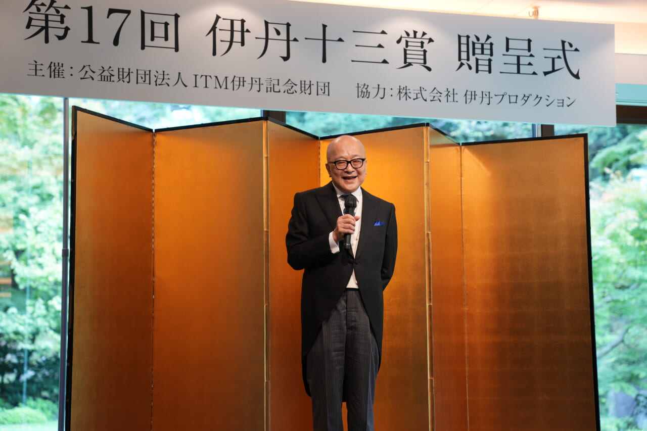 壇上でマイクを持ち、笑いながら話す山田五郎さん。