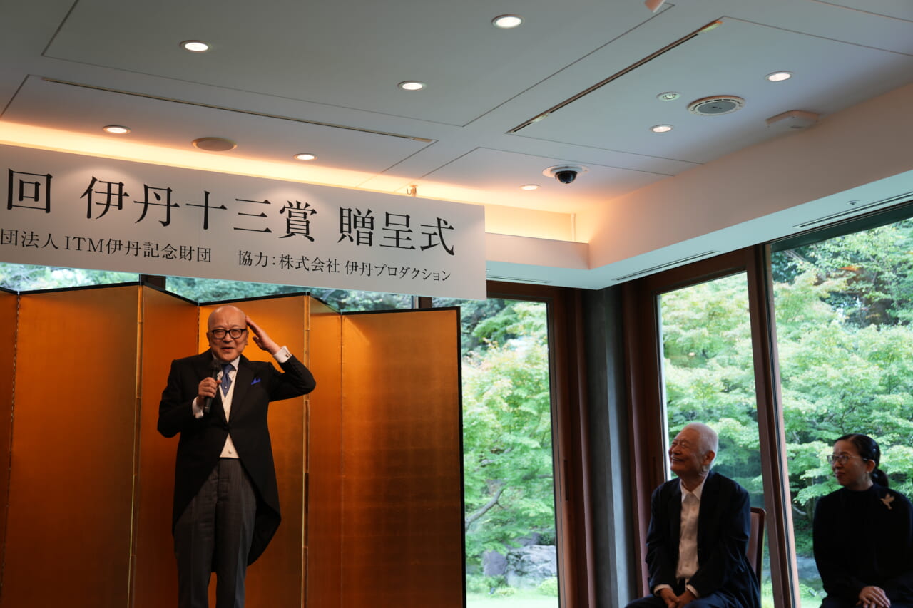 壇上で、頭に手を添えて笑う山田五郎さんを、南伸坊さんと酒井順子さんが笑って見上げています。