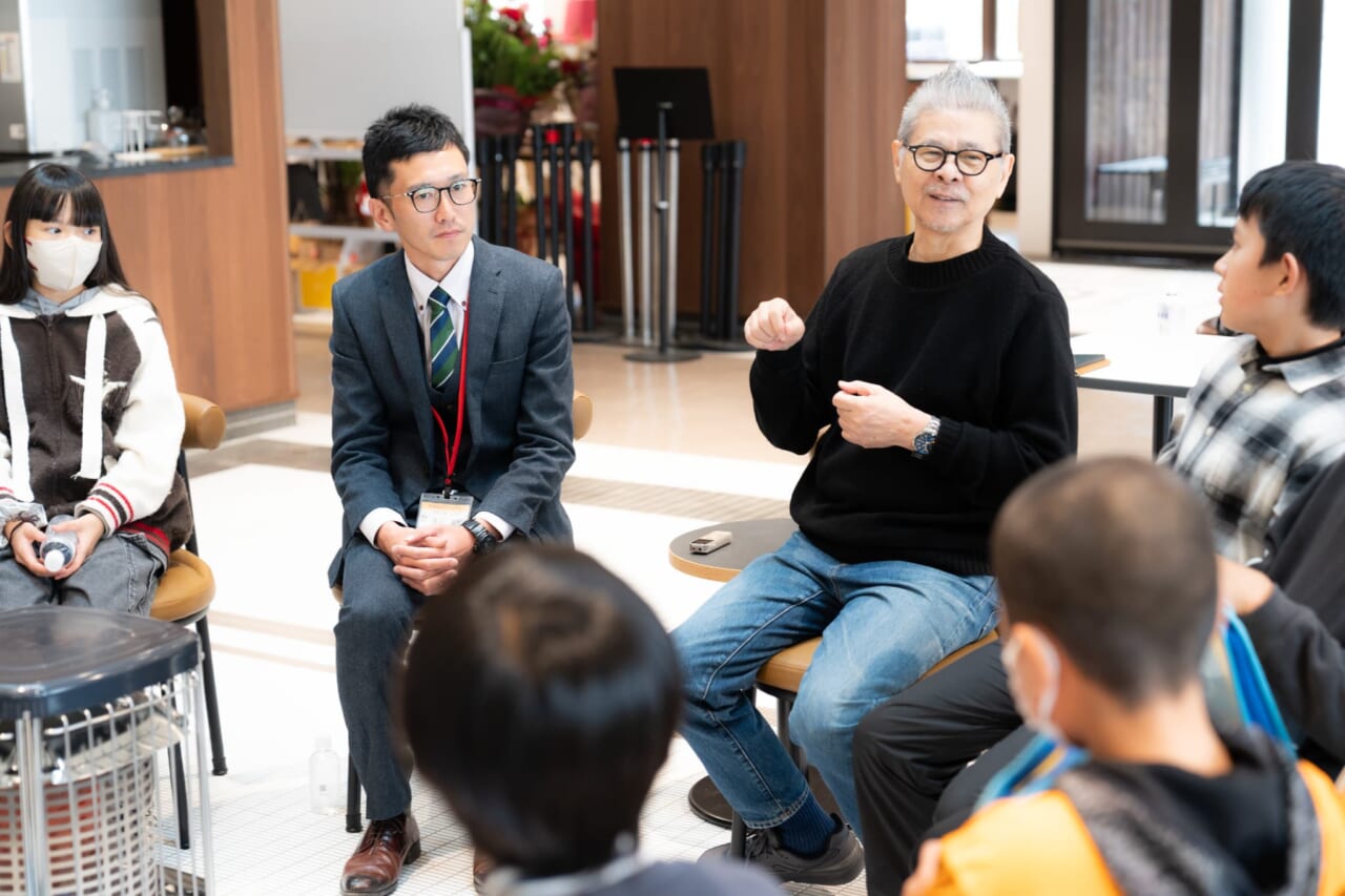 糸井重里が生徒のみなさんに向けて笑顔で話している。