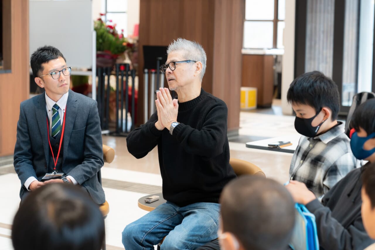 糸井が両手を合わせて「つながっている」ことを示すジェスチャーをしている。