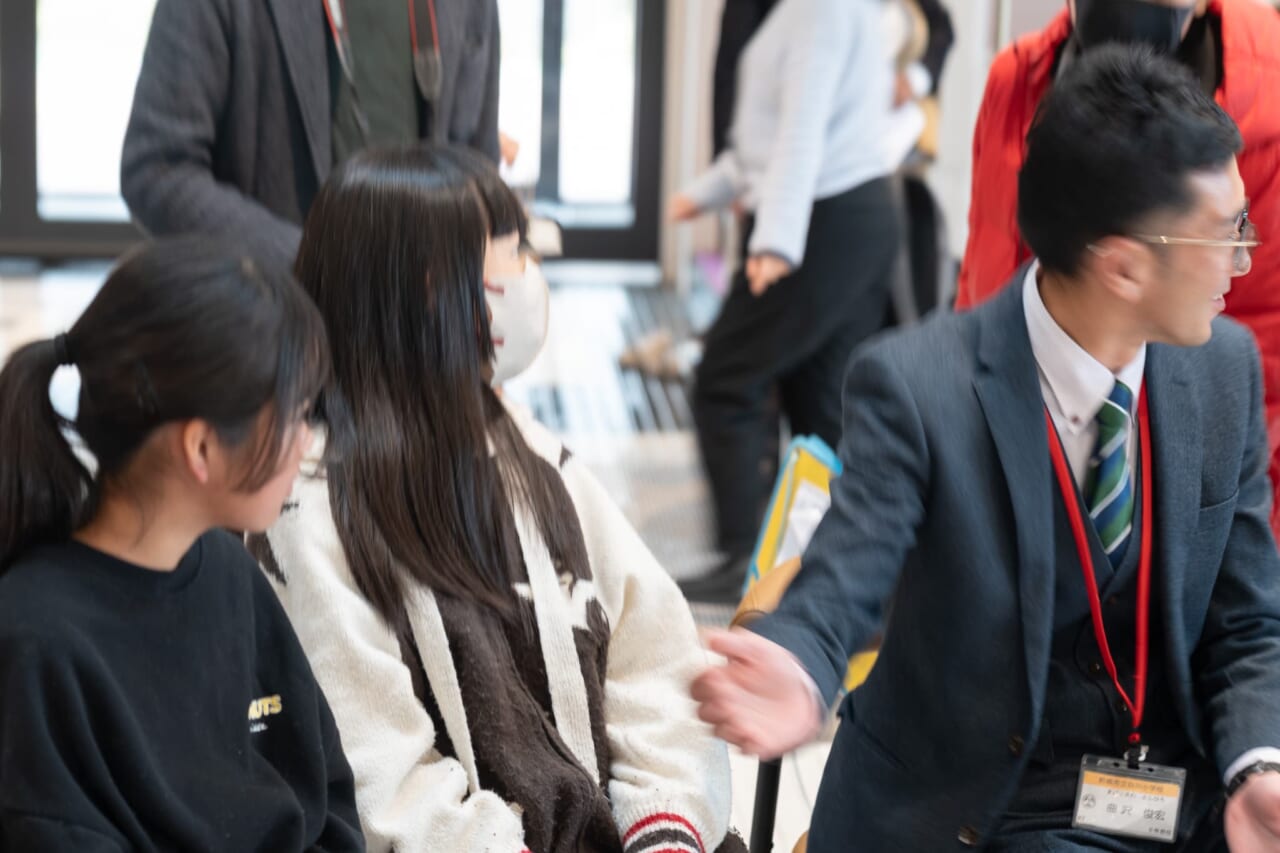 次に質問する、白川小学校のHさんを先生が手で指し示している。