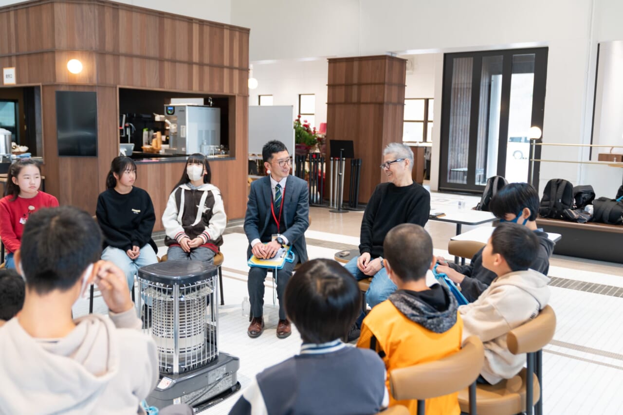 糸井がほほえんでいる。先生も笑顔で聞いている。生徒さんたちも糸井と先生のほうを向いて聞いている。