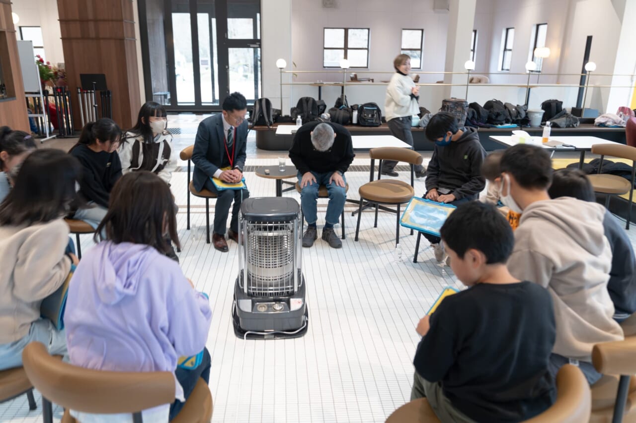 輪になって座った生徒さんたちと糸井が頭を下げている。