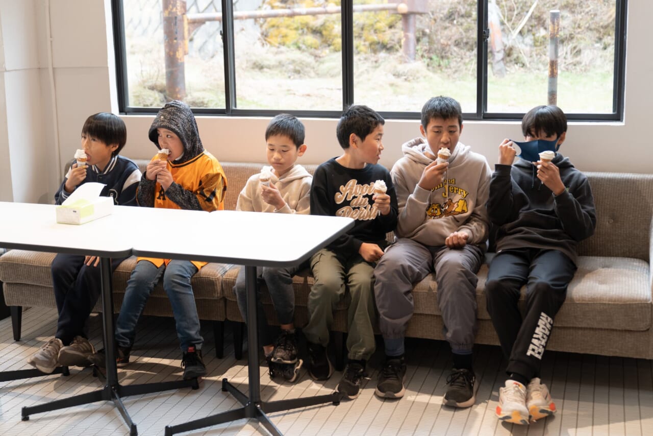 男子生徒さんが６人並んでソフトクリームを食べている。