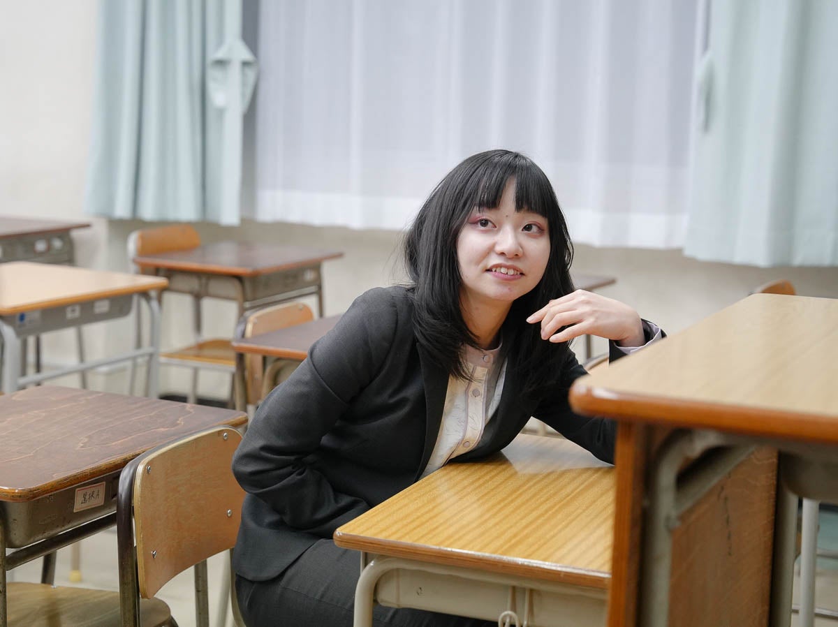 短い金髪に黒いだぼっとした服装の男の子の後ろ姿