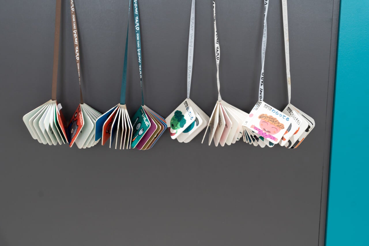 五味さんが手掛けた「ふたごえほん」のシリーズが展示されている。２冊小さな絵本が紐でひとつに繋げられていて、右手に一冊、左手に一冊持って読むことができる。