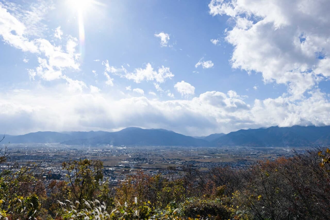 ▲アルプス公園から市街地の眺め。奥に北アルプスの山並み。