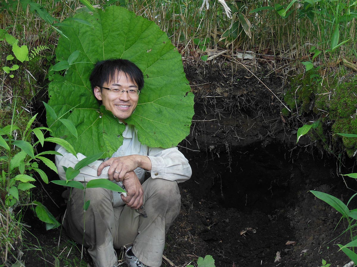 巨大な葉っぱの真ん中をくり抜いたところから顔を出している藤井先生